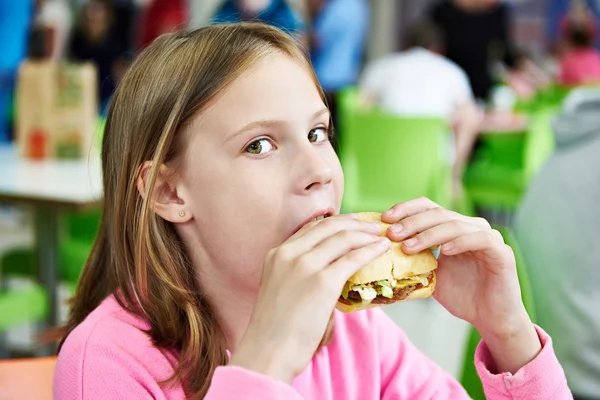 Menina comendo sanduíche no café — Fotografia de Stock