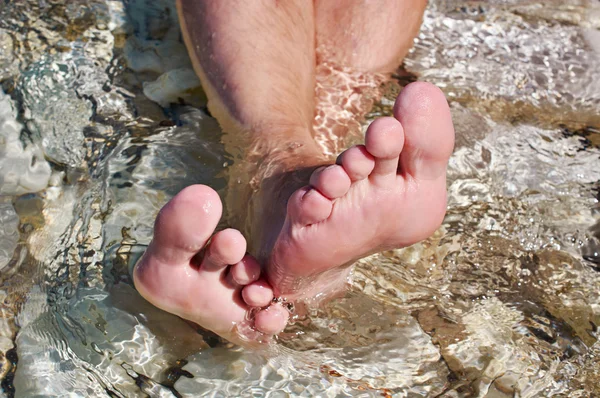 Мужские ноги в морской воде — стоковое фото