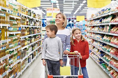 Women and children with cart shopping in supermarket clipart