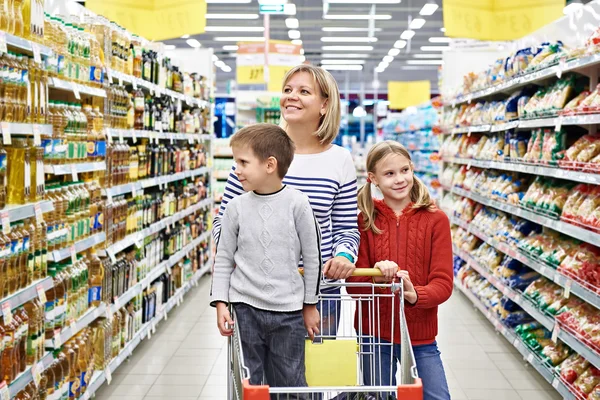 Frauen und Kinder mit Einkaufswagen im Supermarkt — Stockfoto