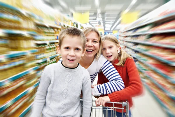 Женщины и дети с корзиной в супермаркете — стоковое фото