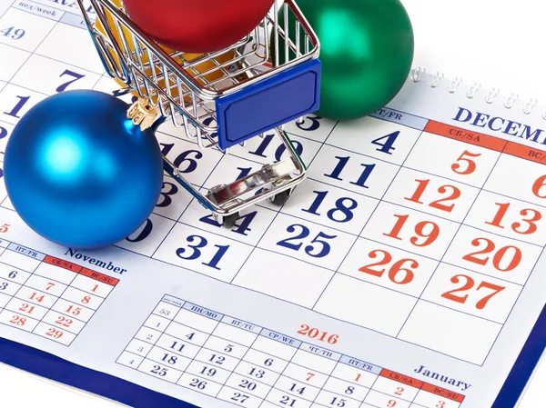 Nákupní vozíky a vánoční koule v kalendáři — Stock fotografie