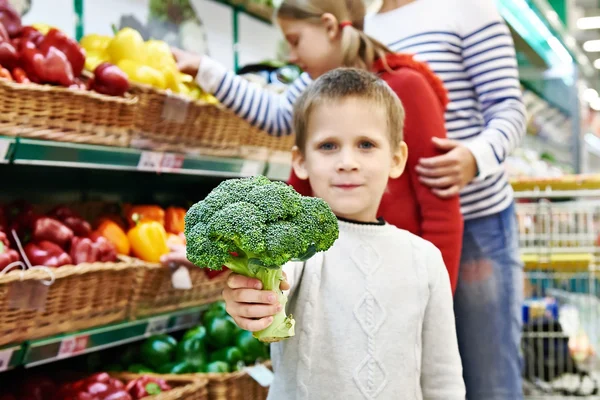 Boy shows broccoli — 图库照片