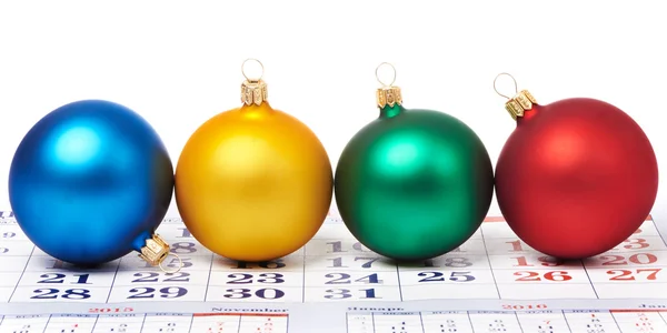 Christmas balls on calendar — Stock Photo, Image