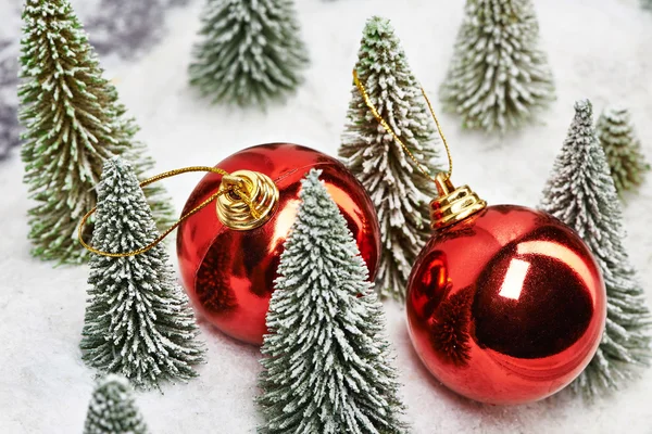 Natal bolas vermelhas perto de brinquedos árvores — Fotografia de Stock