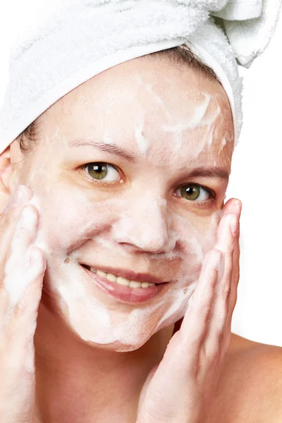 Женщина очищает кожу лица пеной — стоковое фото