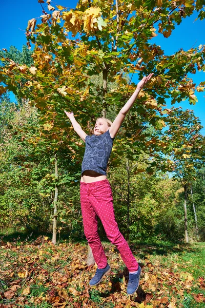 Menina pulando no belo parque de outono — Fotografia de Stock