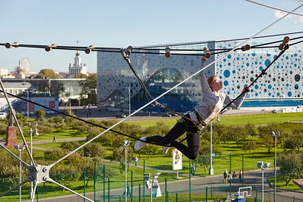 Girl athlete runs an obstacle course in climbing park — Stock Photo, Image