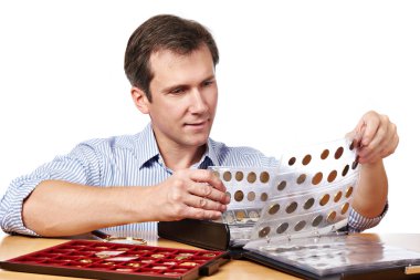 Man numismatist examines his collection of coin clipart