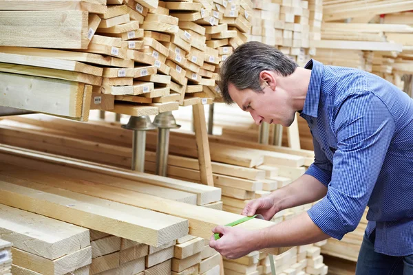 L'homme choisit des planches pour la construction en magasin — Photo