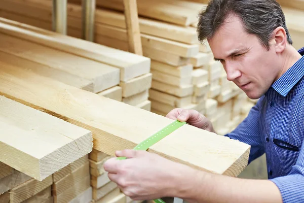 Człowiek wybiera deski na budowę w sklepie — Zdjęcie stockowe
