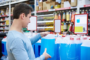 Man buys nonfreezing liquid in supermarket clipart