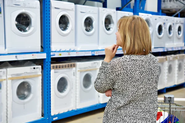 La donna sceglie la lavatrice in negozio di elettrodomestici — Foto Stock