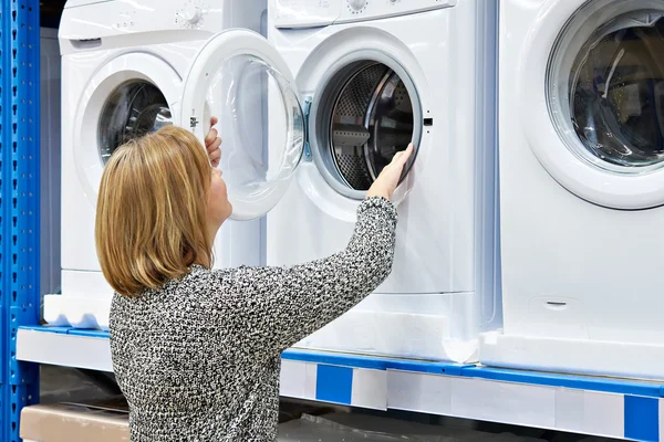 Donna casalinga sceglie lavatrice nel negozio di elettrodomestici — Foto Stock