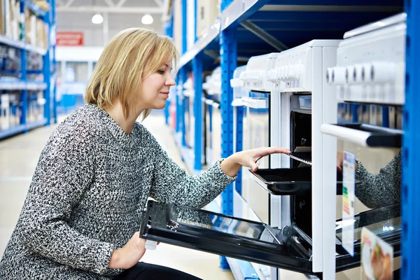 Vrouw huisvrouw kiest gas-kookplaat in de winkel-toestellen — Stockfoto