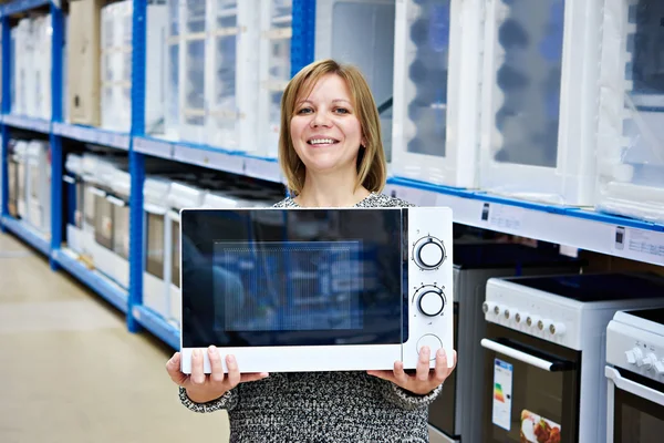 Szczęśliwa kobieta klient kupuje kuchenka mikrofalowa w sklepie — Zdjęcie stockowe