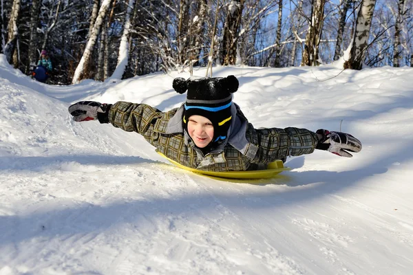 Little boy riding with hills on sleds — Stock Photo, Image