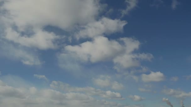Timelapse κυματιστά σύννεφα σε ένα μπλε ουρανό πάνω από την πόλη — Αρχείο Βίντεο