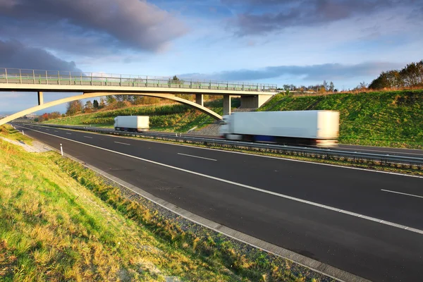 Vrachtwagen vervoer op de weg onder brug — Stockfoto