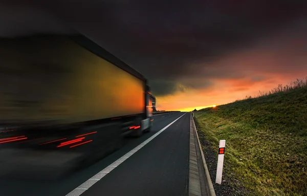 Transporte de caminhão na estrada ao pôr do sol — Fotografia de Stock