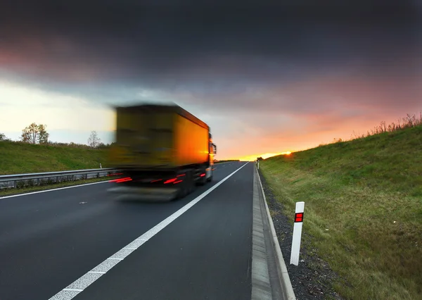 Transporte de caminhão na estrada ao pôr do sol — Fotografia de Stock