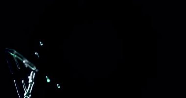 Parlak cyan DNA sarmalının çarpıcı bir 3D görüntüsü moleküler bileşenlerinden yavaşça çıkıyor ve siyah bir arkaplan üzerinde dönüyor. Işıldayan, şeffaf yapı ve ince tırnak işaretleri