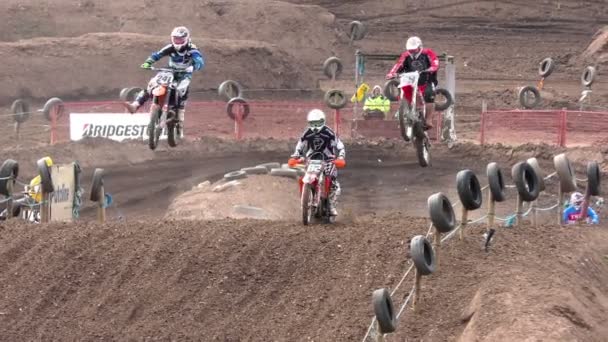 Motocross motorbike rides take large leaps during a race — Stock Video