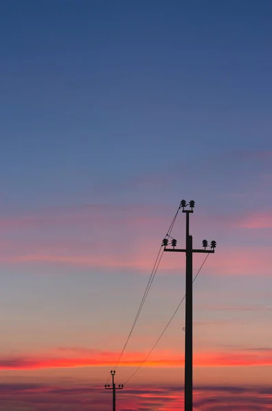 明るい日没 高電圧線の背景に電力線のシルエット — ストック写真