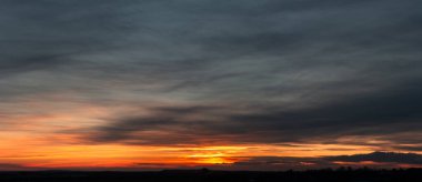 Parlak doygun günbatımının dramatik kasvetli manzarası. Bir sürü kara bulutla.
