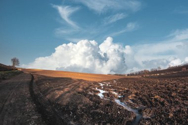 Baharda bitkisiz tarım alanı. Yağmur üstüne yağmur yağdı. Çiftlik arazisi üzerinde yağışlı gökyüzü