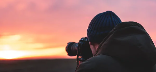 The photographer on the sunset shooting sunset landscape. Travel nature photography.