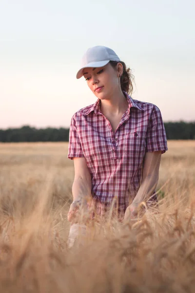 ライ麦畑のキャップの美しい女の子 若いです女の子で小麦畑で日没の背景 — ストック写真