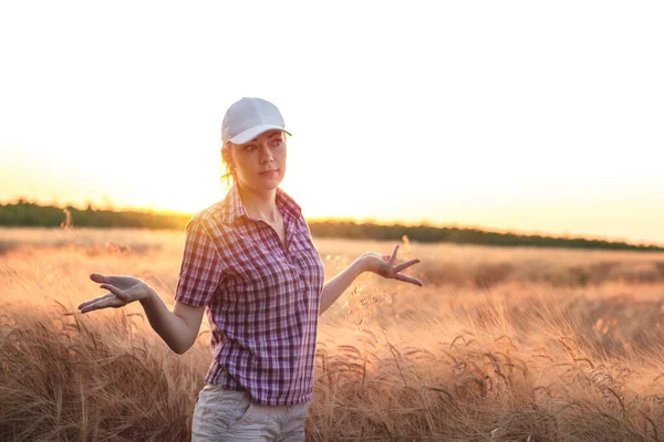 Çavdar tarlasında şapkalı güzel bir kız. Buğday tarlasında gün batımında genç bir kız.