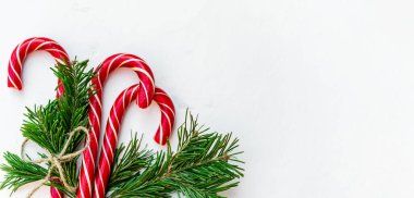 Noel arkaplanı, baston şekerlerle süslenmiş ve üzerinde köknar ağacı dalları olan bir halatla aydınlatma masası. Tebrik etmek için en üstteki Xmas arkaplanı. Geniş bayrak.