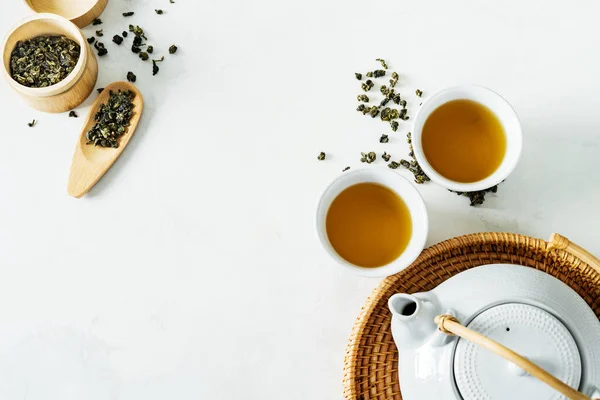 アジア茶のコンセプト 緑茶に囲まれた2つの白茶とティーポット乾燥した葉の上からの眺め 白い背景のテキストのスペース — ストック写真