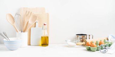 Mutfak arka planında yumurta, merdane, beyaz arka plandaki masada pişirme ve pişirme aletleri için kâseler. Mesaj atmak için boş bir alan, mutfak dekorasyonu konsepti. Geniş pankart.