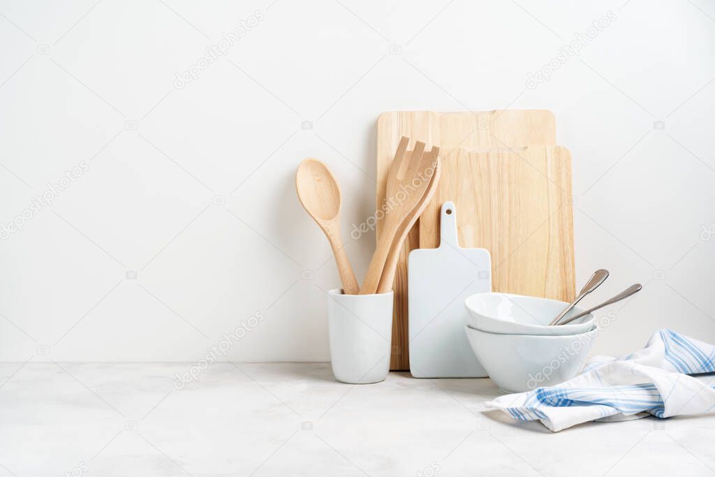 Kitchen background mockup with cooking dishes, baking utensils rolling pin, cutboard, bowls on the table on white background. Blank space for a text, home kitchen decor concept. 
