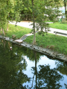 Avusturya. Klagenfurt. Kanalların ve göllerin sularındaki ağaçların ve çalıların yansıması..                               