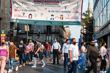 Hispanik maskeli insanlar korumalı abluka noktasından geçiyorlar.