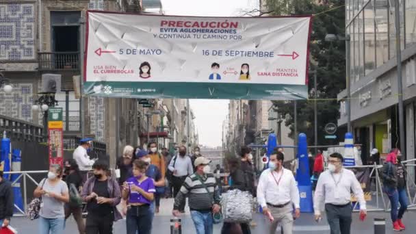 Maskerte latinamerikanere som går gjennom bevoktede sperreposter – stockvideo