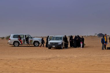Horimlaa, Saudi Arabia - January 7, 2021: Saudi female supporters wearing black abayas and niqabs on Dakar Rally 2021