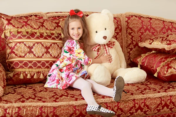 ソファの上のクマと女の子 — ストック写真