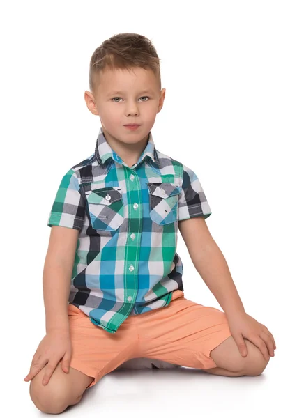 The boy sits on the floor — Stock Photo, Image