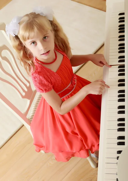 Menina sentada ao piano — Fotografia de Stock
