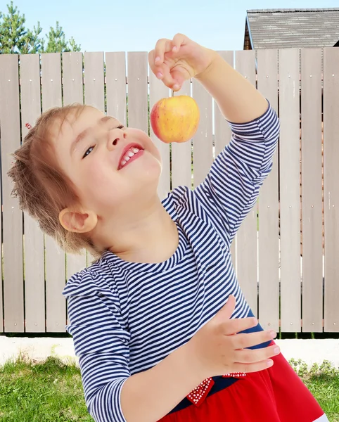 Het meisje kijkt naar de appel — Stockfoto