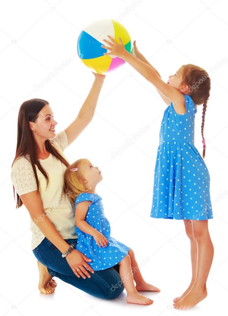 Mother with her daughters playing with a ball
