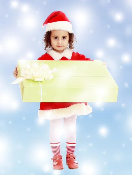 Little girl in costume of Santa Claus with gift — Stock Photo, Image