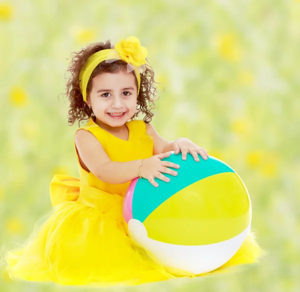 Niña en vestido amarillo con gran bola — Foto de Stock