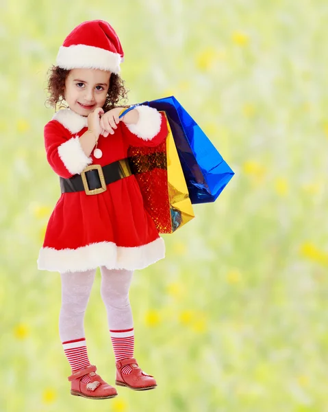 Little girl in costume of Santa Claus with colorful packages — Stock Photo, Image