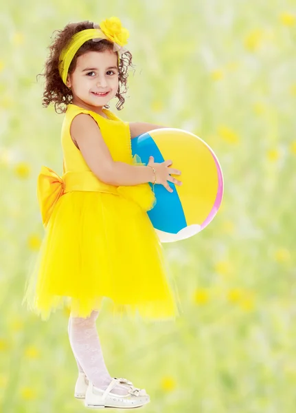 Little girl in yellow dress with big ball — Stock Photo, Image